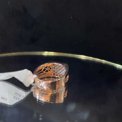 A gold band ring with smaller round cut diamonds is displaying on a reflective surface.