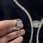 A man's hand displaying a gold band ring with smaller round cut diamonds.