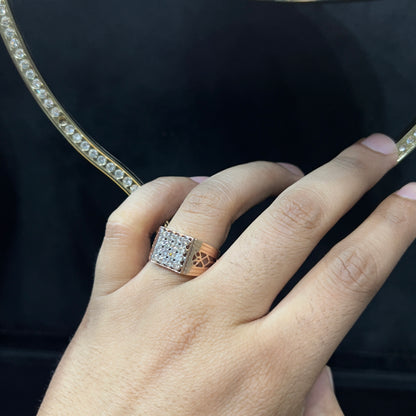 A man's hand displaying a gold band ring with smaller round cut diamonds.