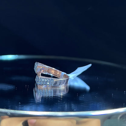 A reflective surface displaying a 14K gold diamond ring with a solid band and a small diamond inlay on the top surface.