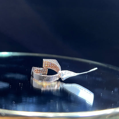 A reflective surface displaying a 14K gold diamond ring with a solid band and a small diamond inlay on the top surface.