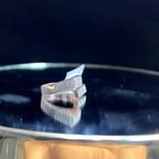 A reflective surface displaying a 14K gold diamond ring with a solid band and a small diamond inlay on the top surface.