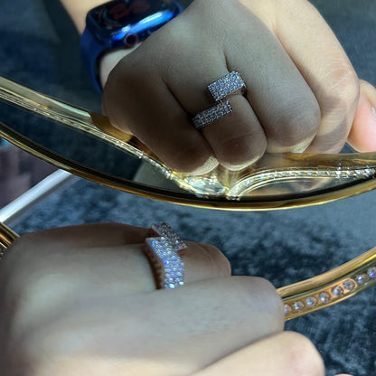 Two man's hand displaying two gold diamond ring with a solid band and a small diamond inlay on the top surface.