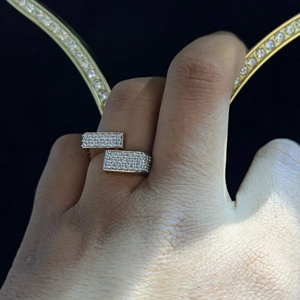 A man's hand displaying a 14K gold diamond ring with a solid band and a small diamond inlay on the top surface.