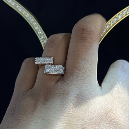 A man's hand displaying a 14K gold diamond ring with a solid band and a small diamond inlay on the top surface.