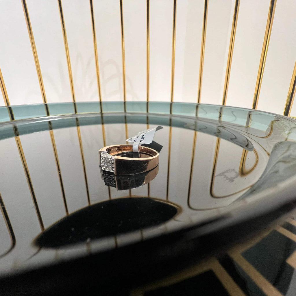 A man's hand holding a gold-banded ring with a large, clear crystal on top, and a smaller, real diamond on the band.