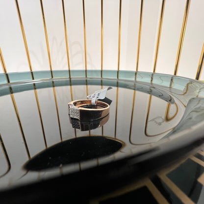 A man's hand holding a gold-banded ring with a large, clear crystal on top, and a smaller, real diamond on the band.