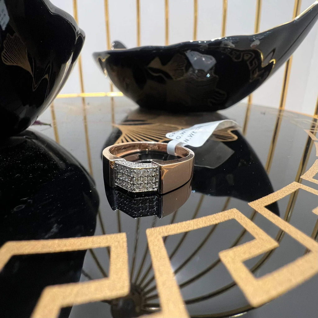 A man's hand holding a gold-banded ring with a large, clear crystal on top, and a smaller, real diamond on the band.
