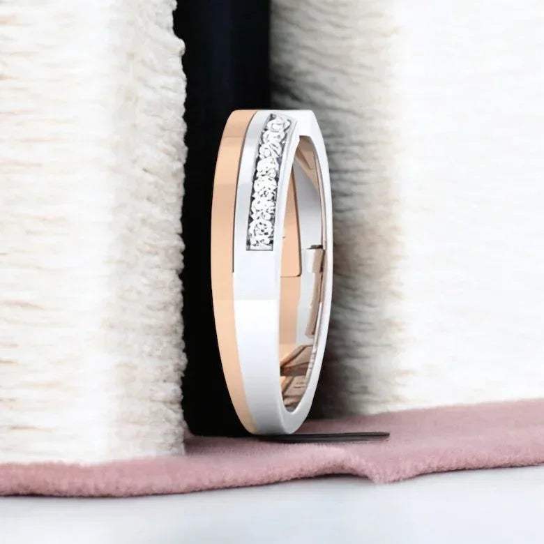 Two tone ring with diamond accents on a textured surface.