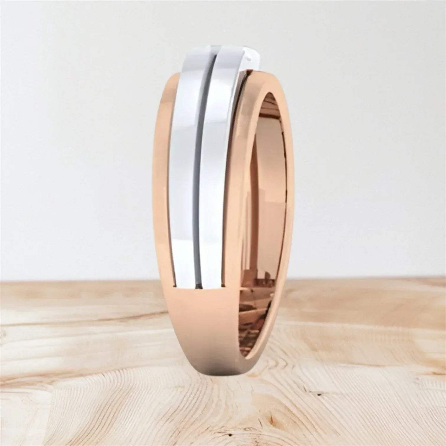 Two-tone diamond ring with rose gold and white gold finish on a wooden surface