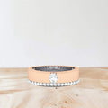 Rose gold ring with a diamond on a wooden surface