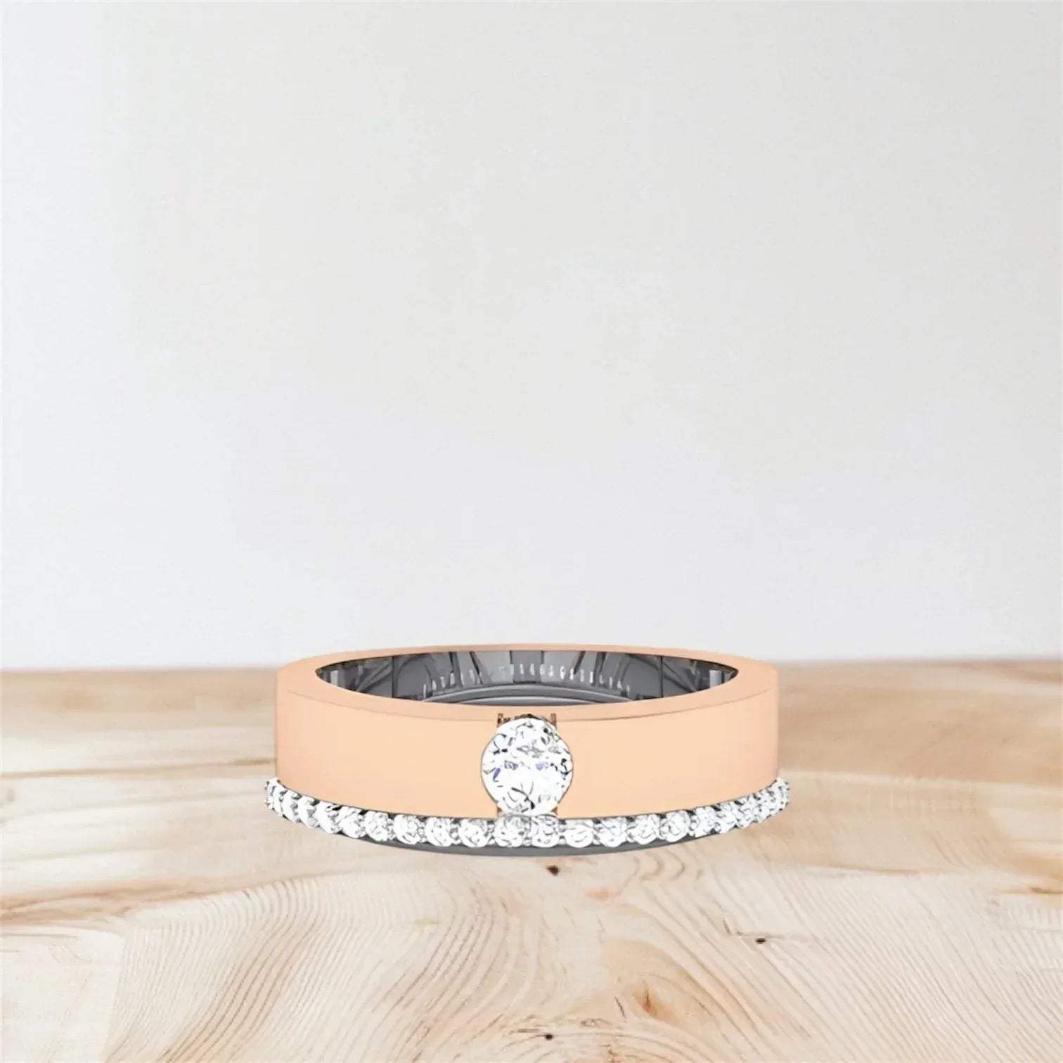 Rose gold ring with a diamond on a wooden surface