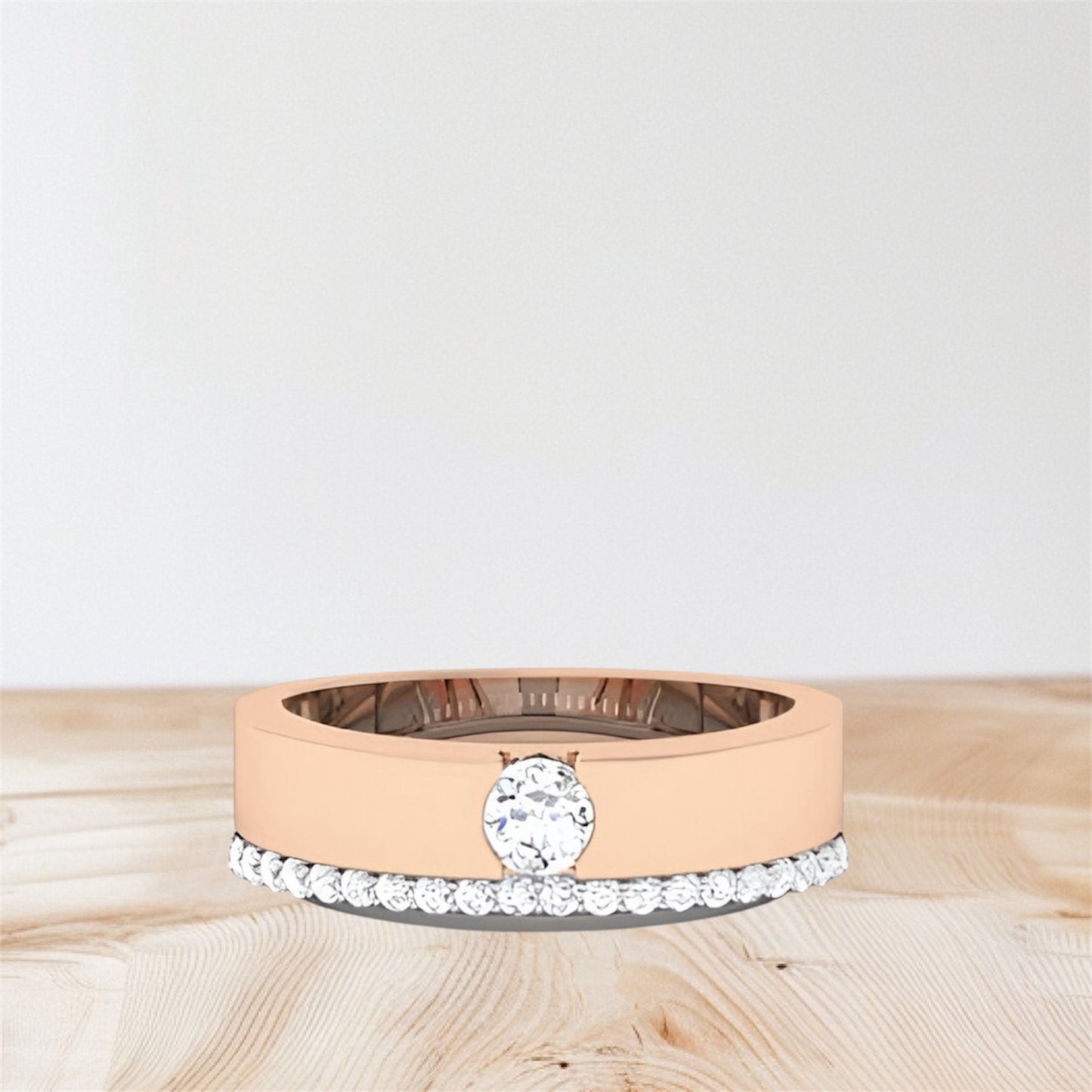 rose gold and white gold rings on a wooden surface with a light gray background.