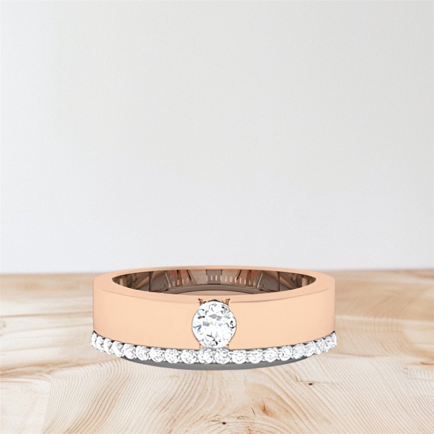 rose gold and white gold rings on a wooden surface with a light gray background.