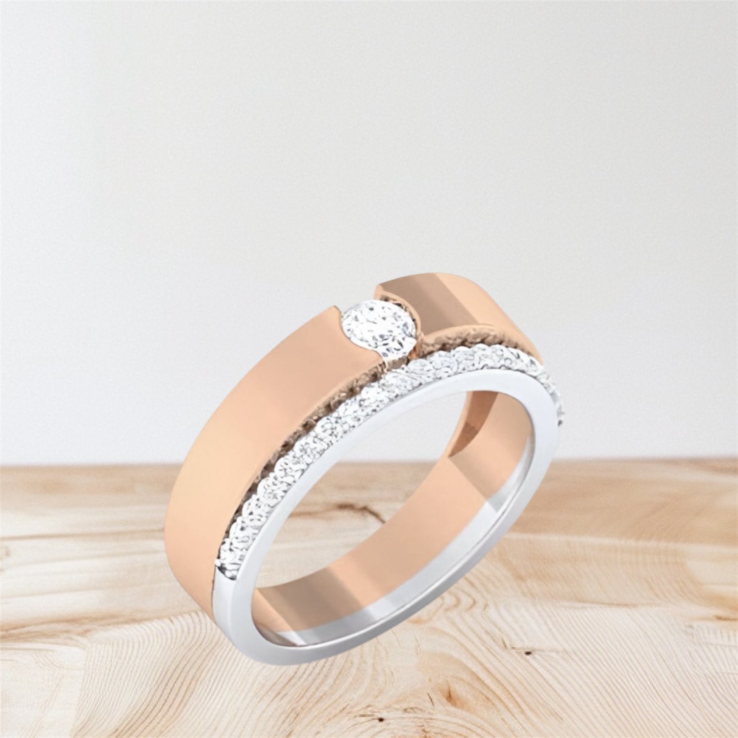 rose gold and white gold rings on a wooden surface with a light gray background