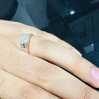 A man's hand displaying a gold diamond ring with a solid band and a small diamond inlay on the top surface.