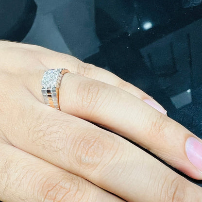 A man's hand displaying a gold diamond ring with a solid band and a small diamond inlay on the top surface.