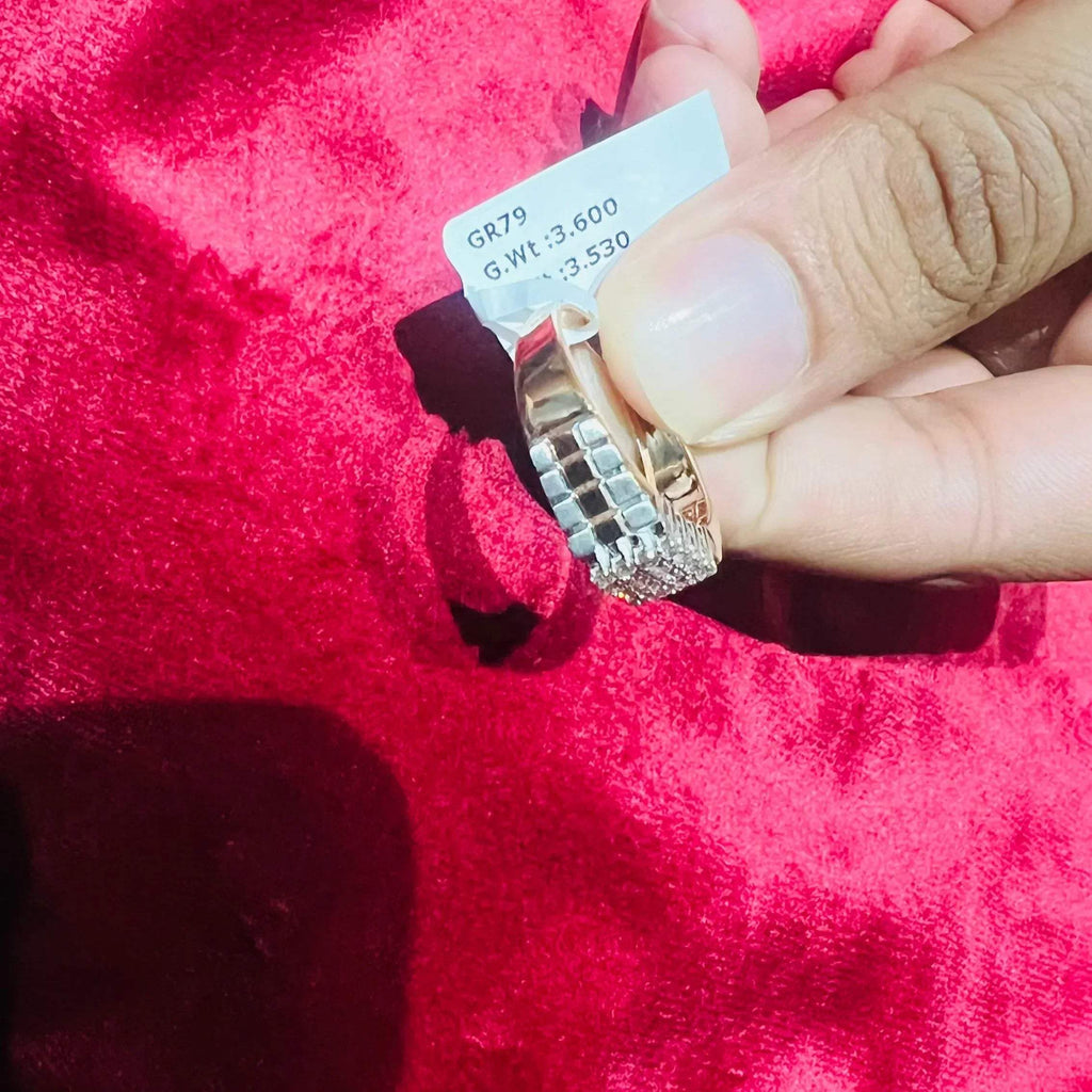 A man's hand displaying a gold diamond ring with a solid band and a small diamond inlay on the top surface.