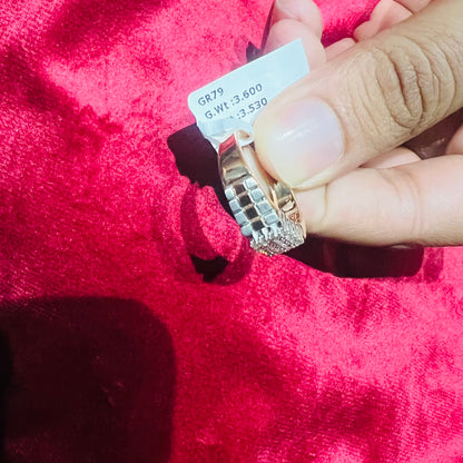 A man's hand displaying a gold diamond ring with a solid band and a small diamond inlay on the top surface.