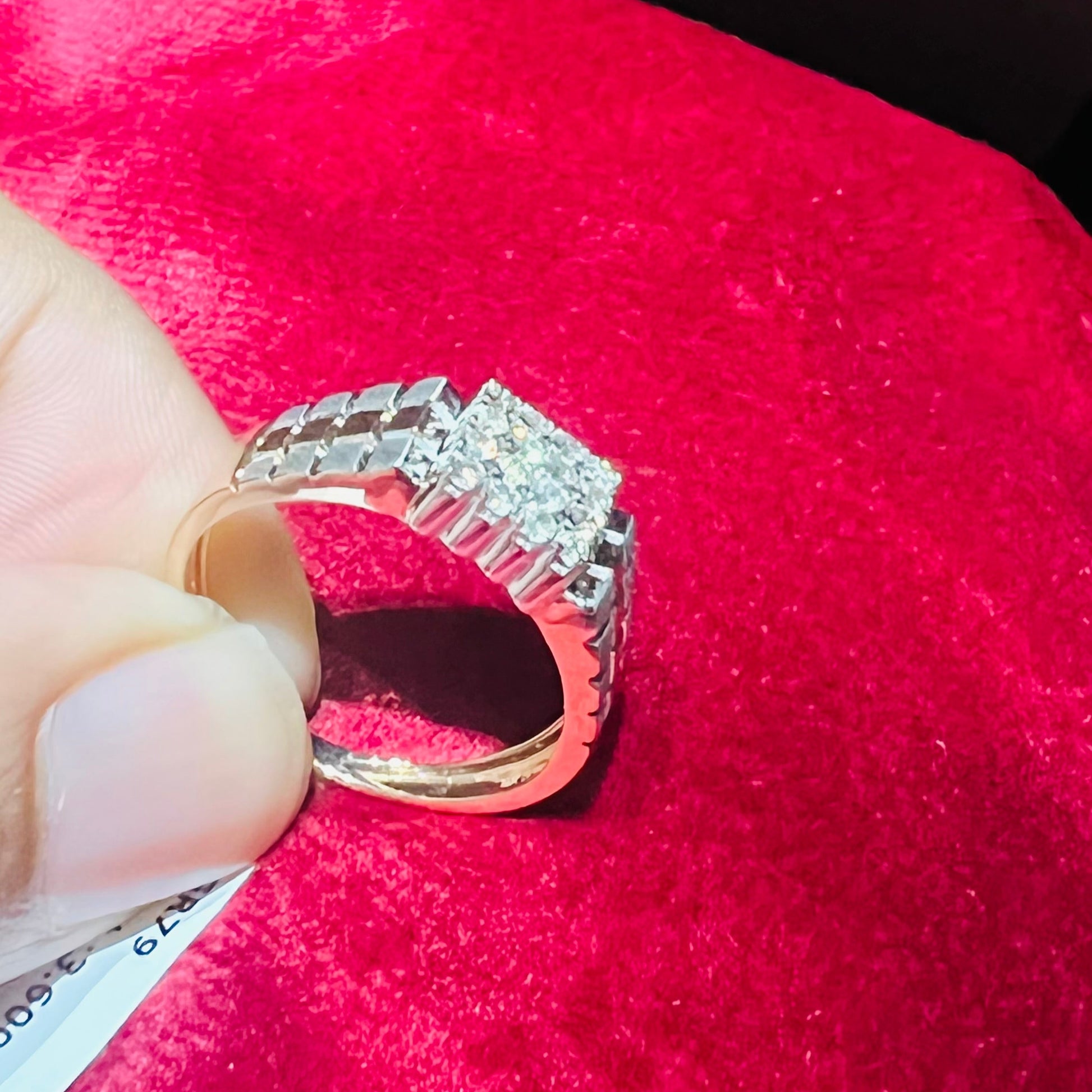 A man's hand displaying a gold diamond ring with a solid band and a small diamond inlay on the top surface.
