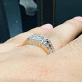A man's hand displaying a gold diamond ring with a solid band and a small diamond inlay on the top surface.