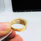 A man's hand displaying a gold band ring with smaller round-cut diamonds from back side.