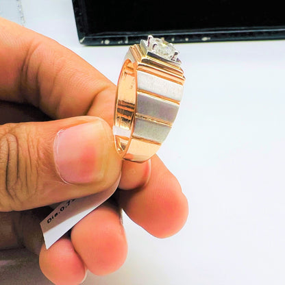 A man's hand holding a solitaire diamond ring with a gold band.