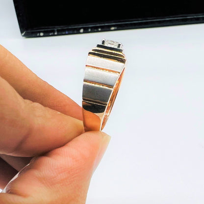 A man's hand showing a solitaire diamond ring with a gold band from vertical side.