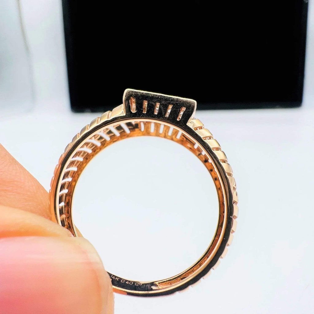 A man's hand displaying a gold diamond ring with round cut diamonds set in a square shape from the side.