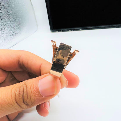 A man's hand displaying a gold diamond ring from the back side.