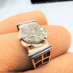 A man's hand displaying a gold band ring with round-cut diamonds set in the band.