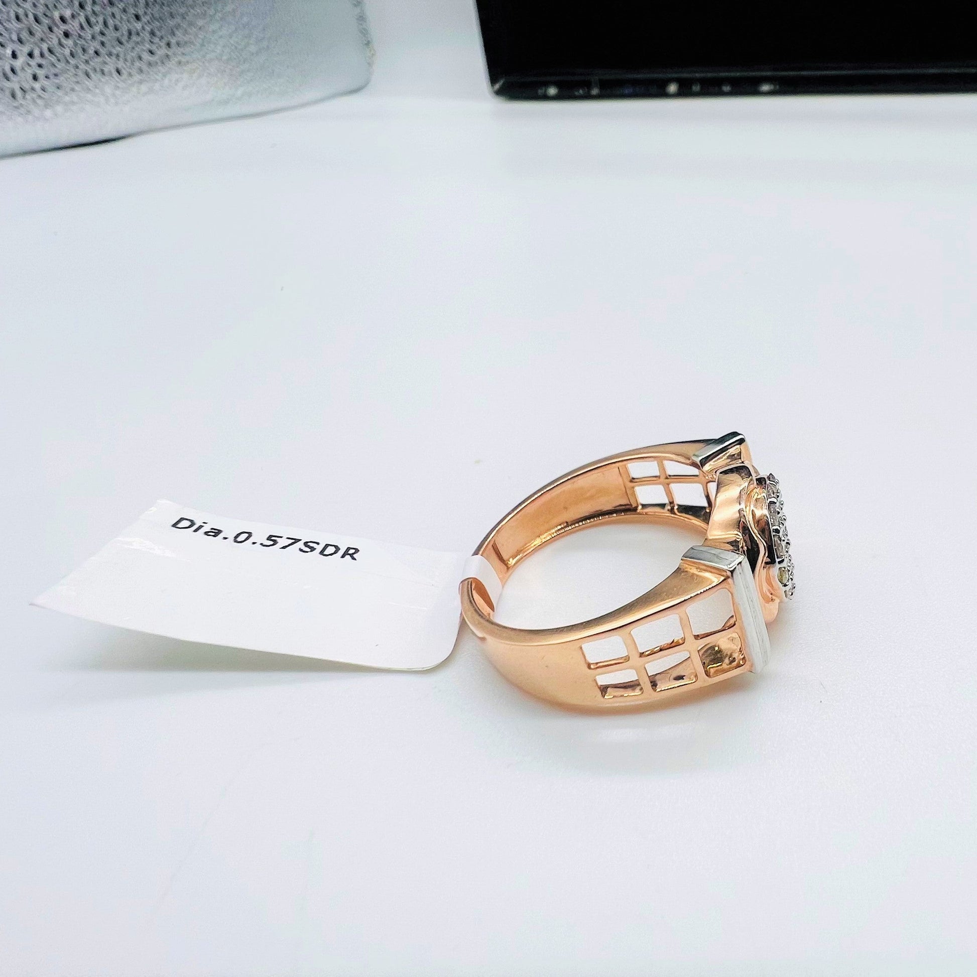 A man's hand displaying a gold band ring with round-cut diamonds set in the band.