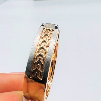 A man's hand displaying a gold band ring with round-cut diamond set in the band.