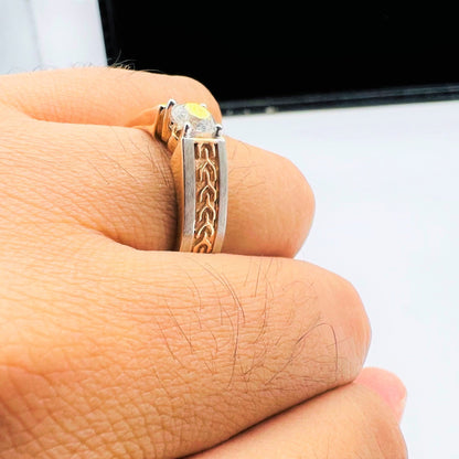 A man's hand displaying a gold band ring with round-cut diamond set in the band.