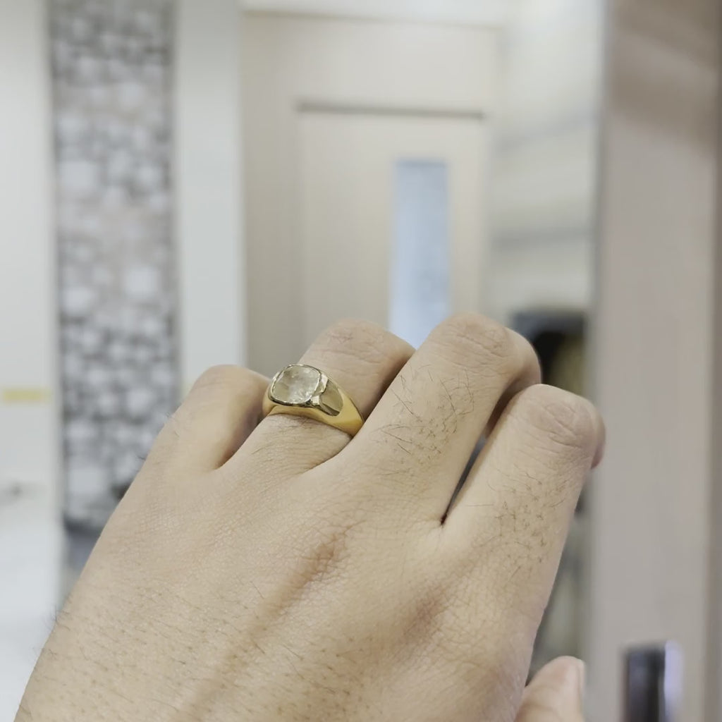 A person's hand is showing from the close which is worn a gold ring with natural sapphire gemstone and tilting hand both sides to show the ring from every angle against a neutral background.