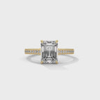 Gold ring with a large baguette-cut diamond and smaller diamonds on the band against a white background, shown from the 360 degree angle.