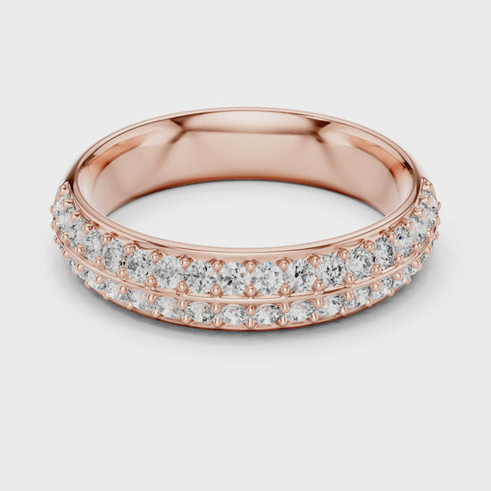 A ring made of rose gold and lab grown diamonds is placed on a white surface and the ring is rotating on the white surface.