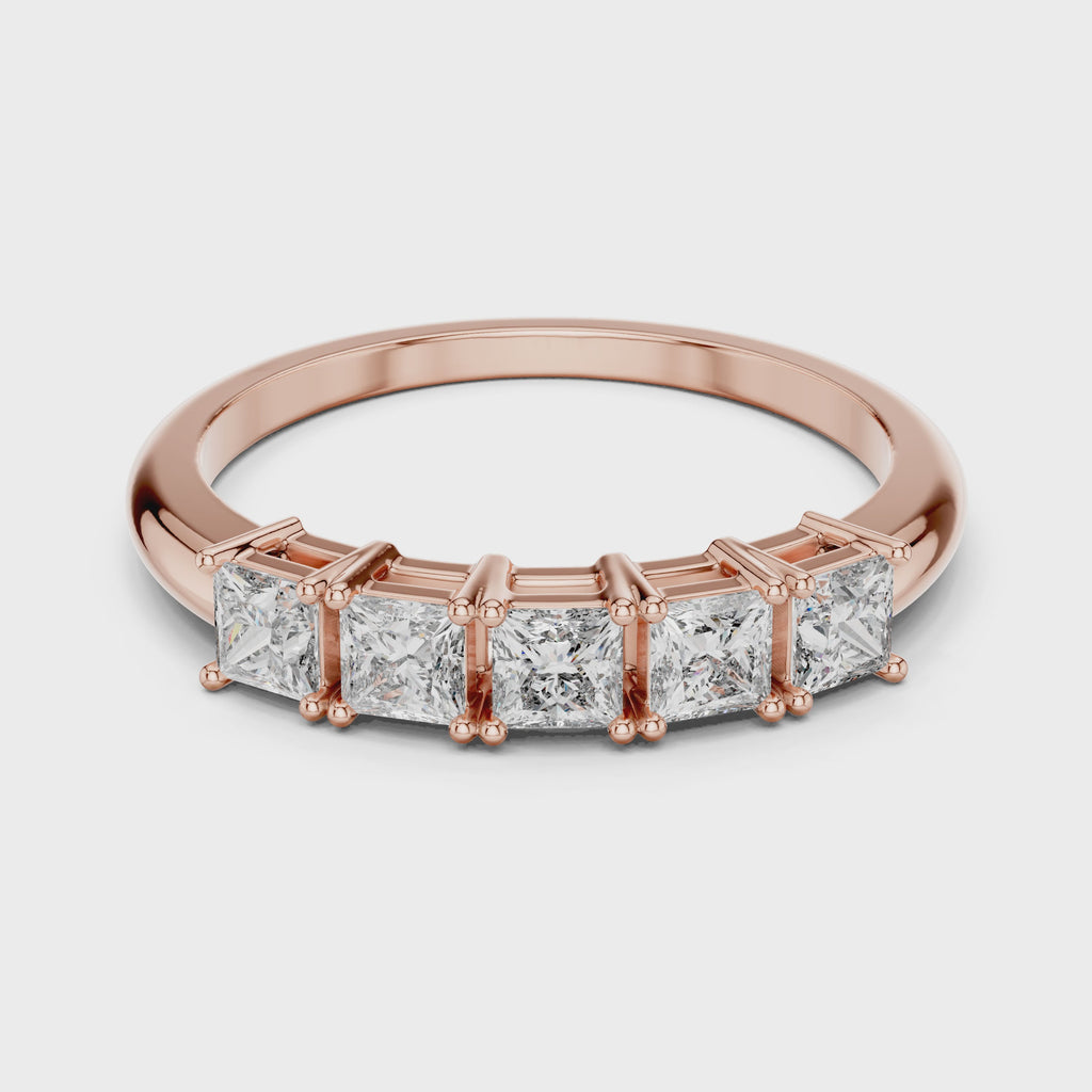 Rose gold ring with clear diamonds is rotating horizontally on a white surface.