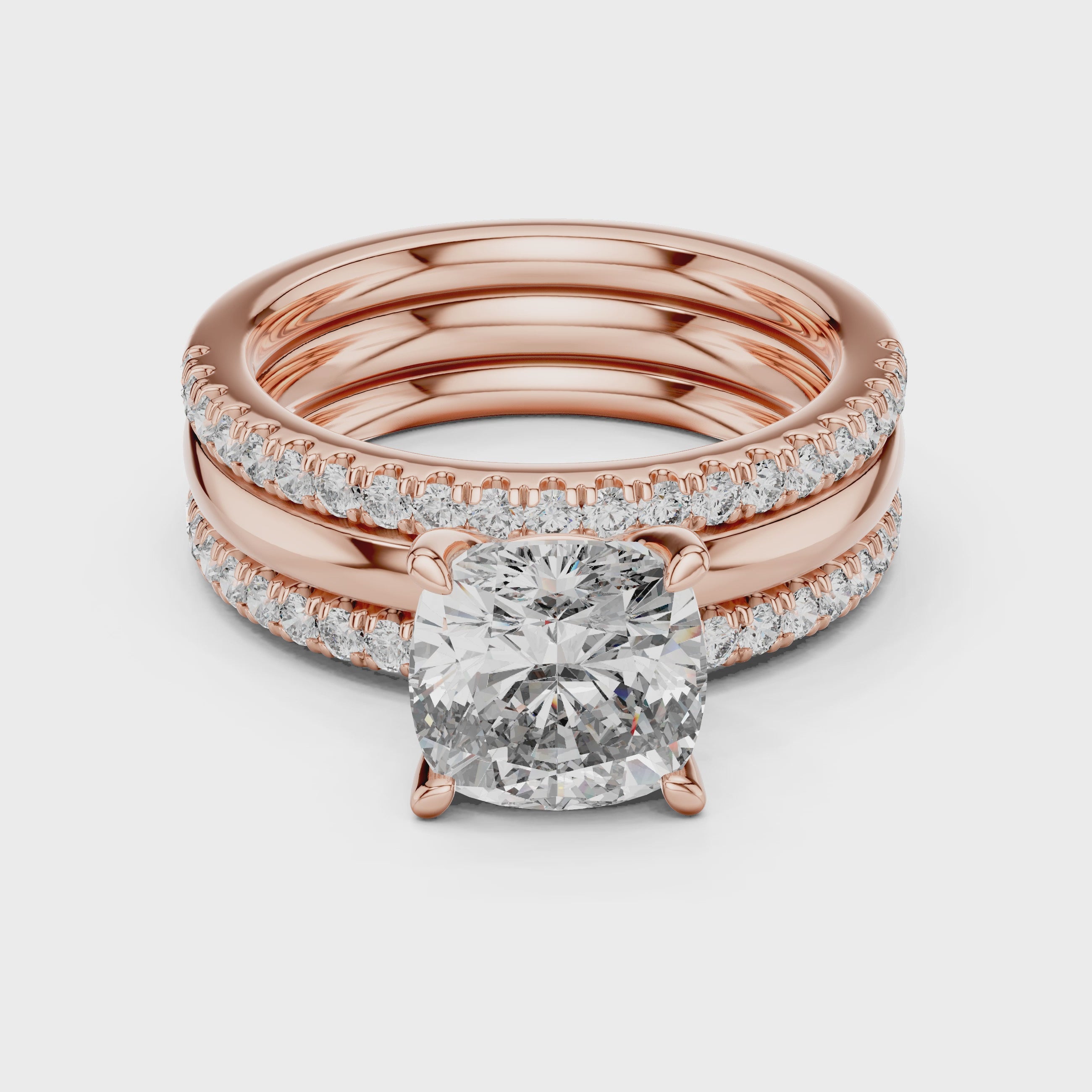Rose gold ring with a large diamond and smaller diamonds is rotating horizontally on a white surface.