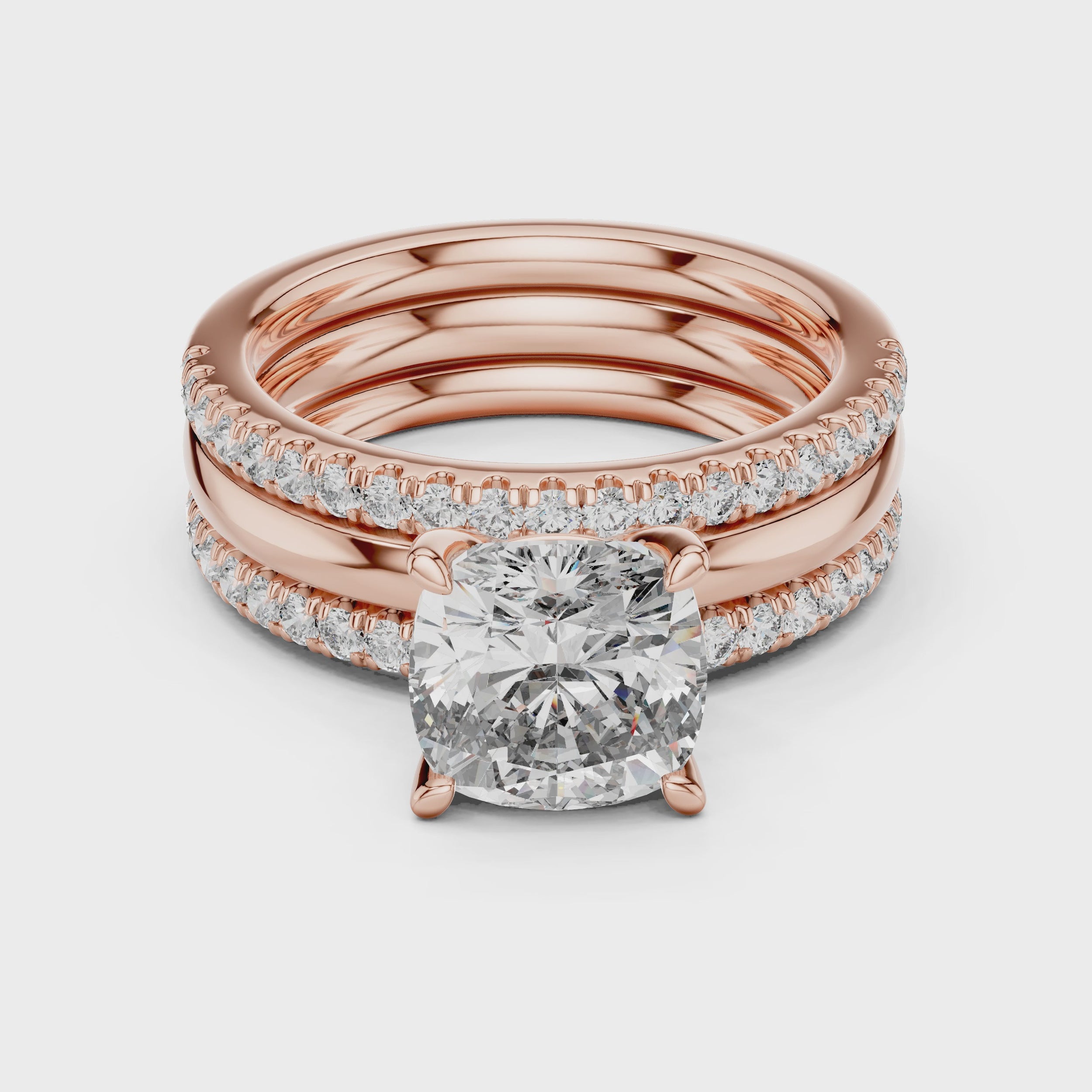 Rose gold ring with a large diamond and smaller diamonds is rotating horizontally on a white surface.