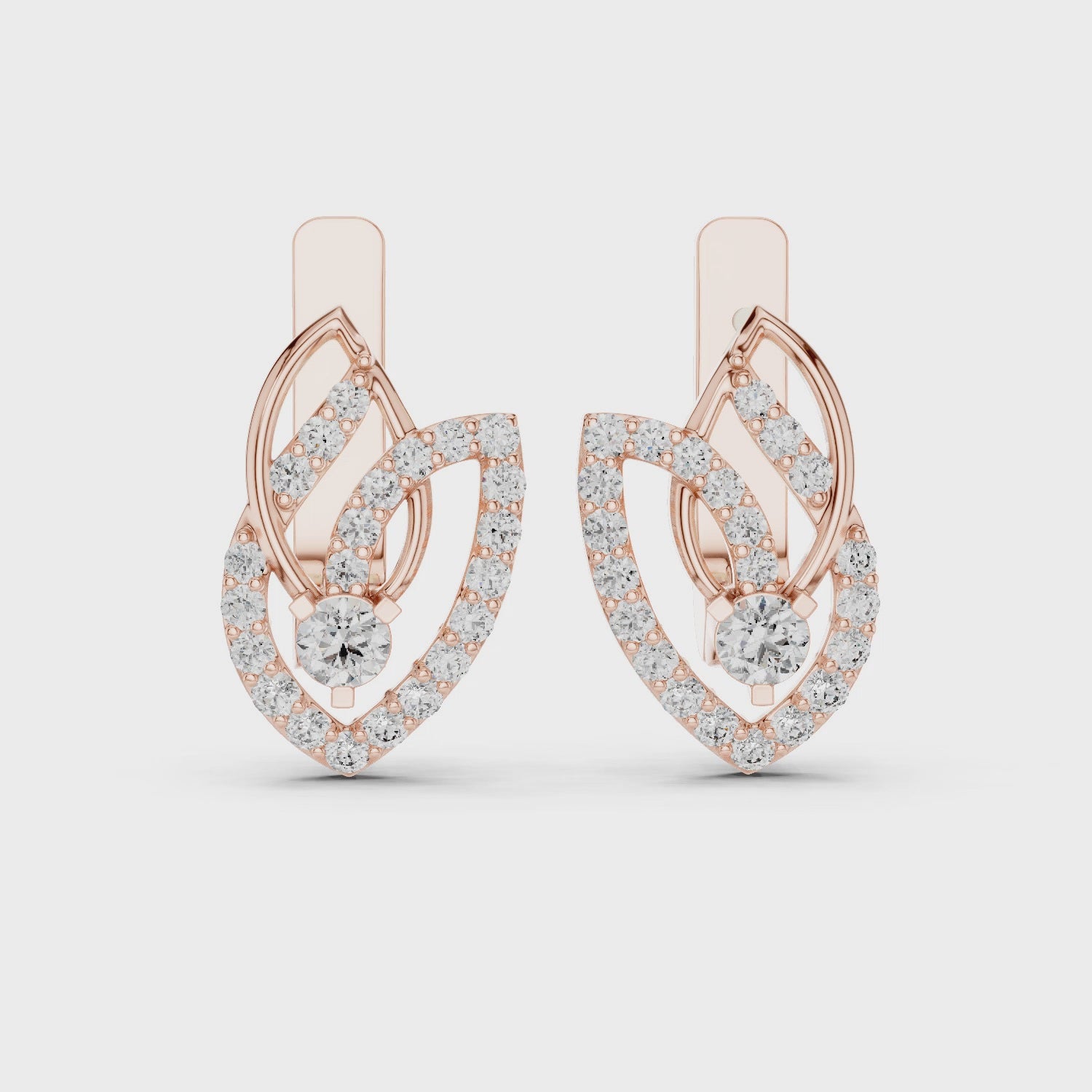 Rose gold and diamonds drop earrings are displaying on a white background and surface.