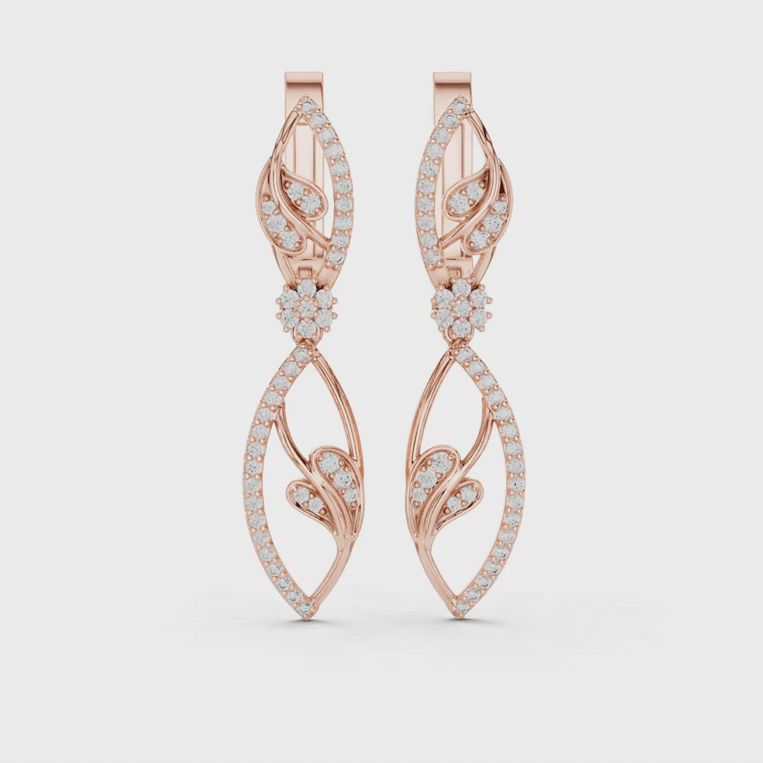 Rose gold earrings with pave set diamonds is rotating horizontally on a white surface.