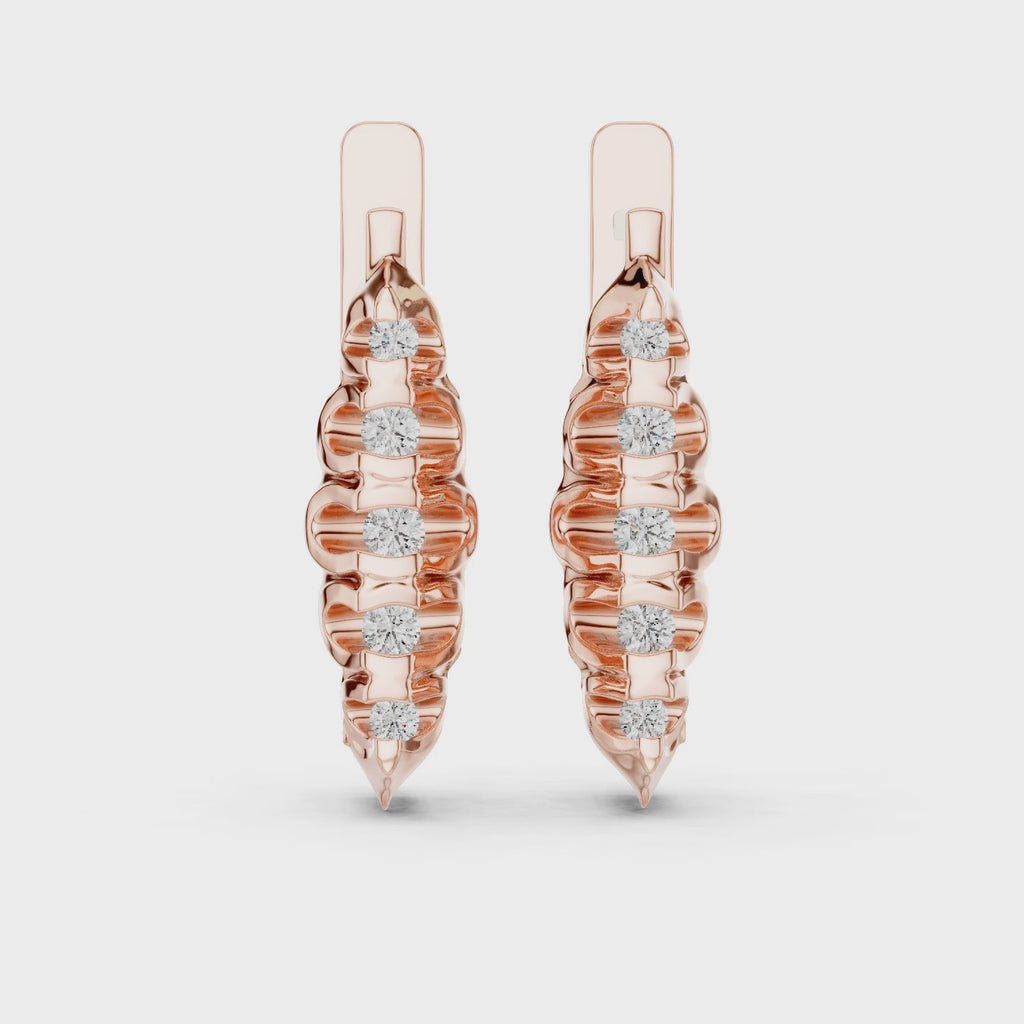 Rose gold earrings with diamonds are rotating horizontally on a white surface.