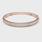 Rose gold bracelet with real diamonds is rotating horizontally on a white surface.