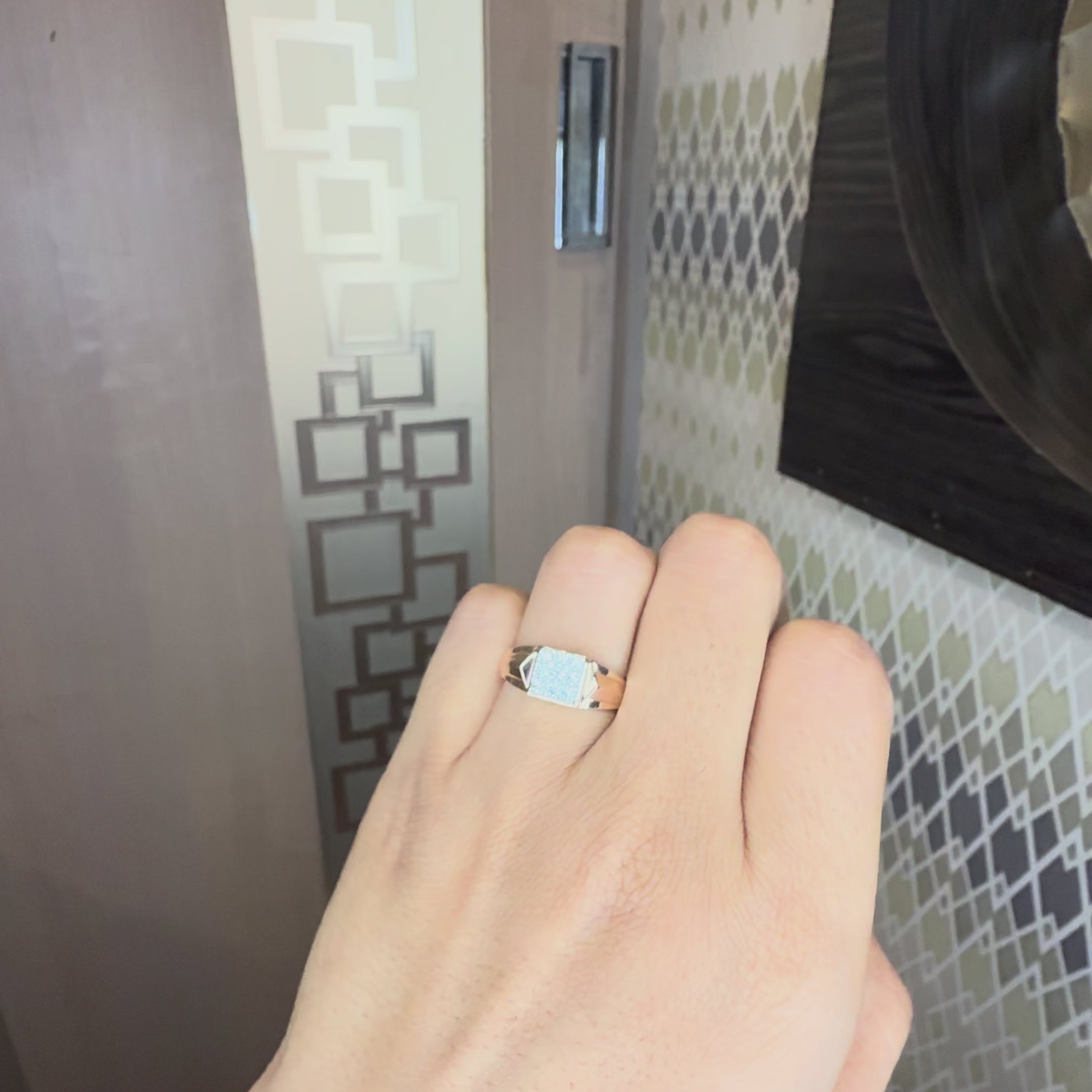 A person's hand is worn yellow gold ring with a square pavé diamond setting, tilting hand both side to show the every view of the ring.