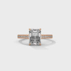 gold ring with emerald-cut diamond and smaller diamonds on a white background is displaying from 360 degree angles