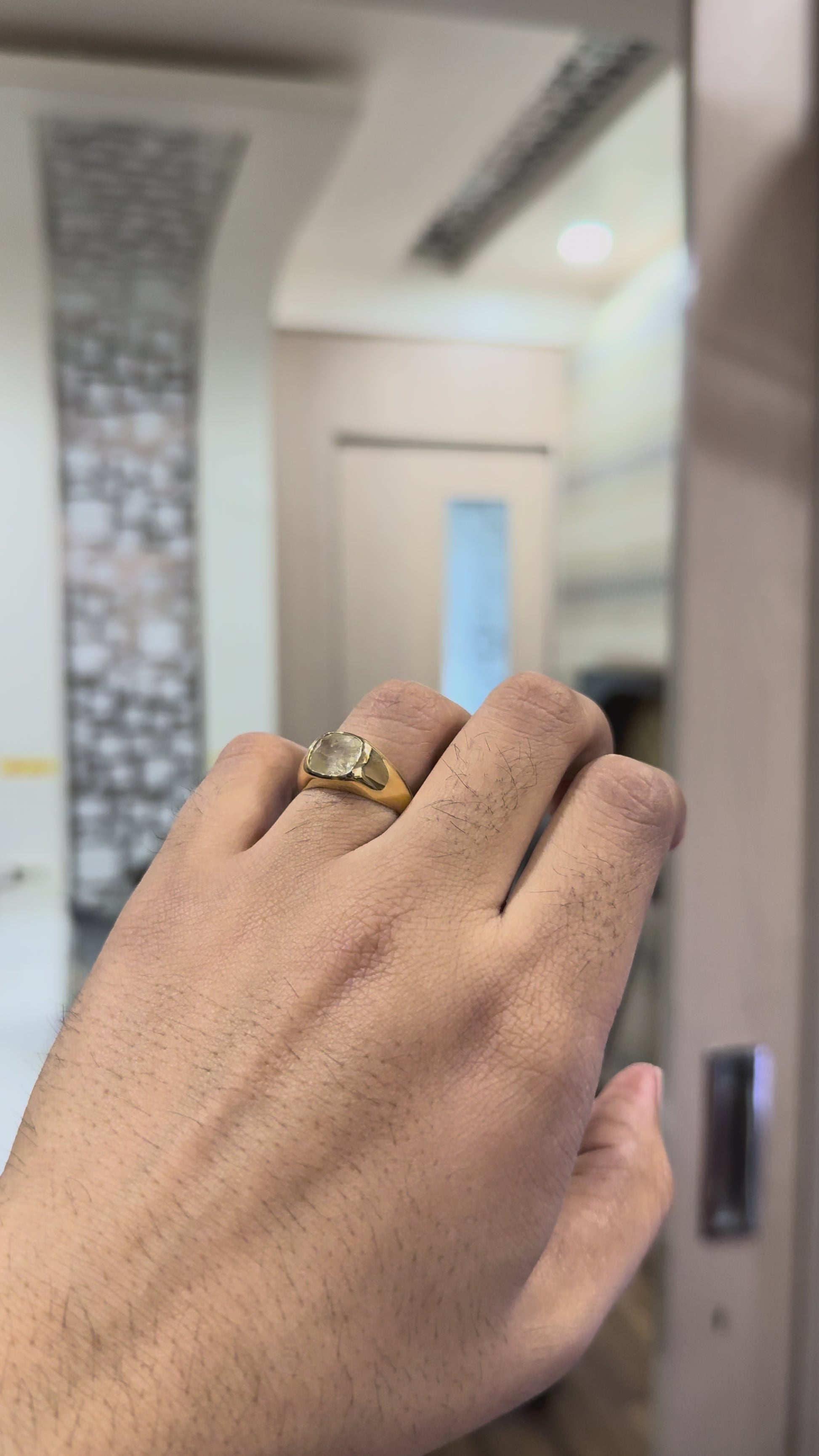 A gold ring with natural yellow sapphire gemstone in a man's finger is displayed.