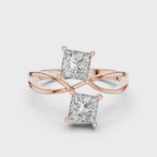 Rose gold ring with two princess-cut lab grown diamonds on a white background, showing from 360 degree angle.