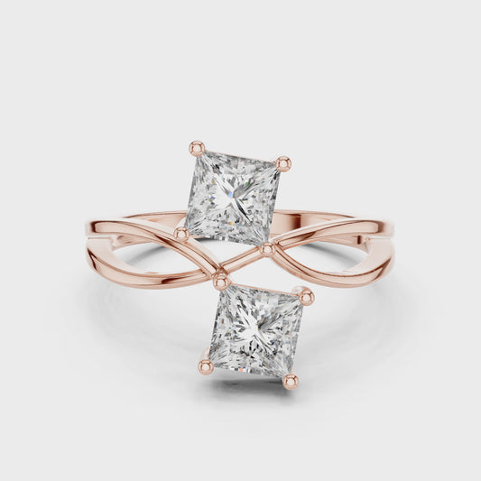 Rose gold ring with two princess-cut lab grown diamonds on a white background, showing from 360 degree angle.
