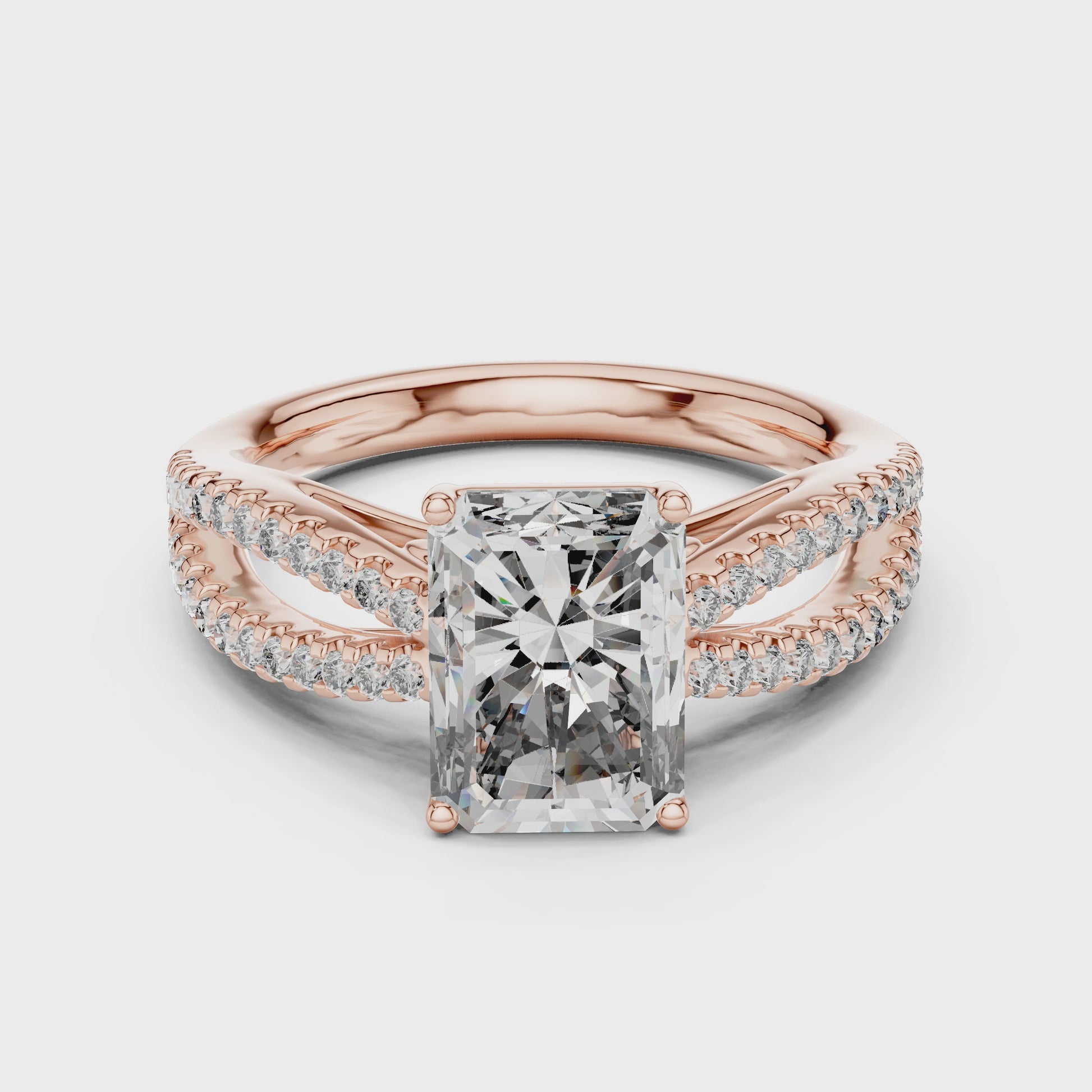 Rose gold ring with a large diamond and smaller diamonds on the band against a white background is rotating on a white surface.